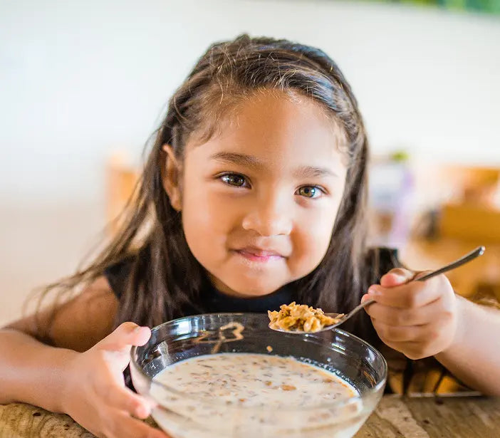 Girl eating granola.