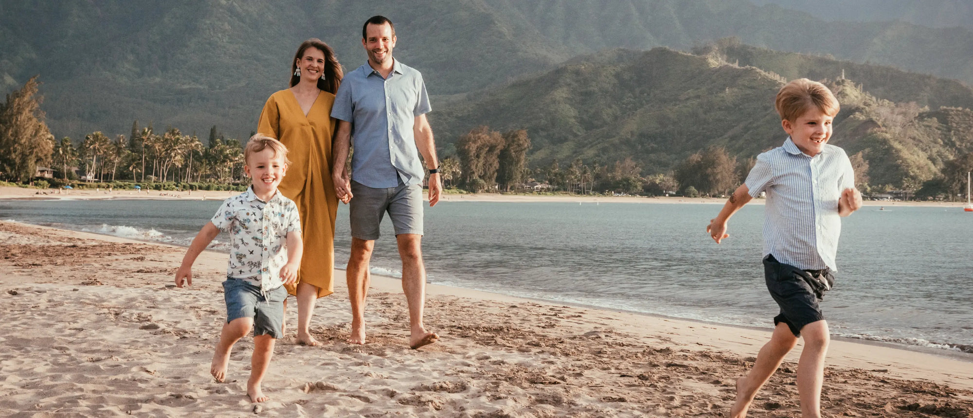 Bill and Malia walking on beach with Malcom and Johnny.